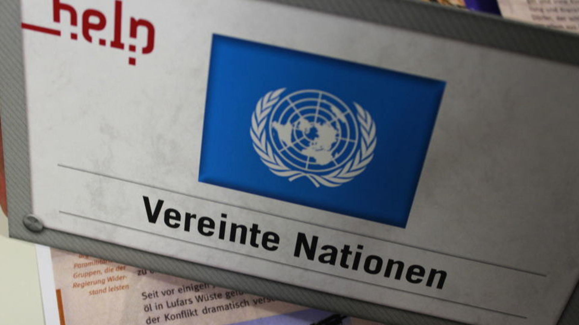 Ein Tischschild des Planspiels Humanitäre Schule mit dem Logo der Vereinten Nationen darauf