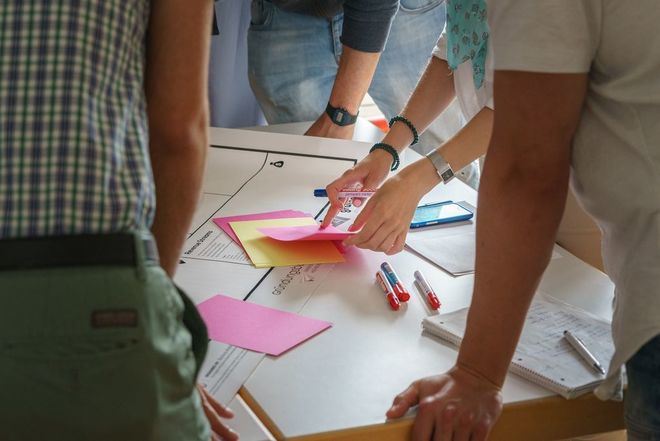 Workshop-Situation: Menschen arbeiten an einem Tisch