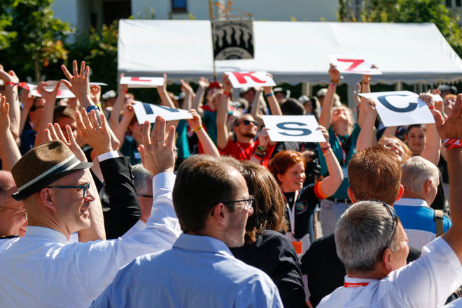 Eine Menschenmenge hält Hände und Schilder in die Luft