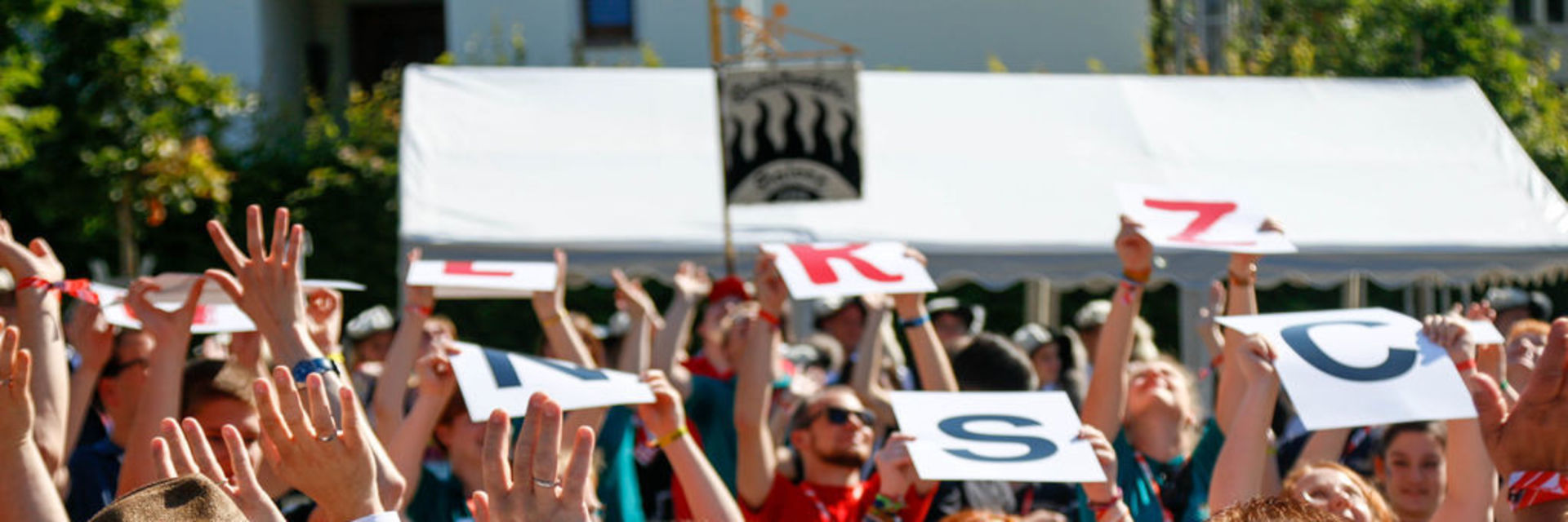 Eine Menschenmenge hält Hände und Schilder in die Luft