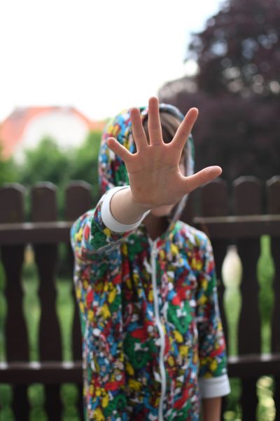 Ein Kind hält die flache Hand ausgestreckt vorsicht, um "Stopp" zu signalisierten Ein Kind hält die flache Hand vor sich ausgestreckt und signalisiert so: Stopp