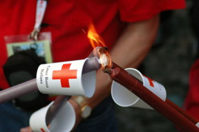 Eine Fackel wird an einer anderen angezündet. 