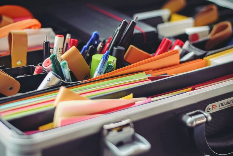 Ausschnitt eines Moderationskoffer (Stifte, Moderationskarten usw.) Nahaufnahme eines geöffneten Moderationskoffers mit buntem Papier und Stiften darin
