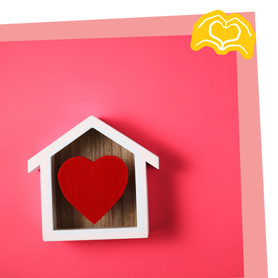 Ein kleines Holzhaus mit einem roten Herzen darin.