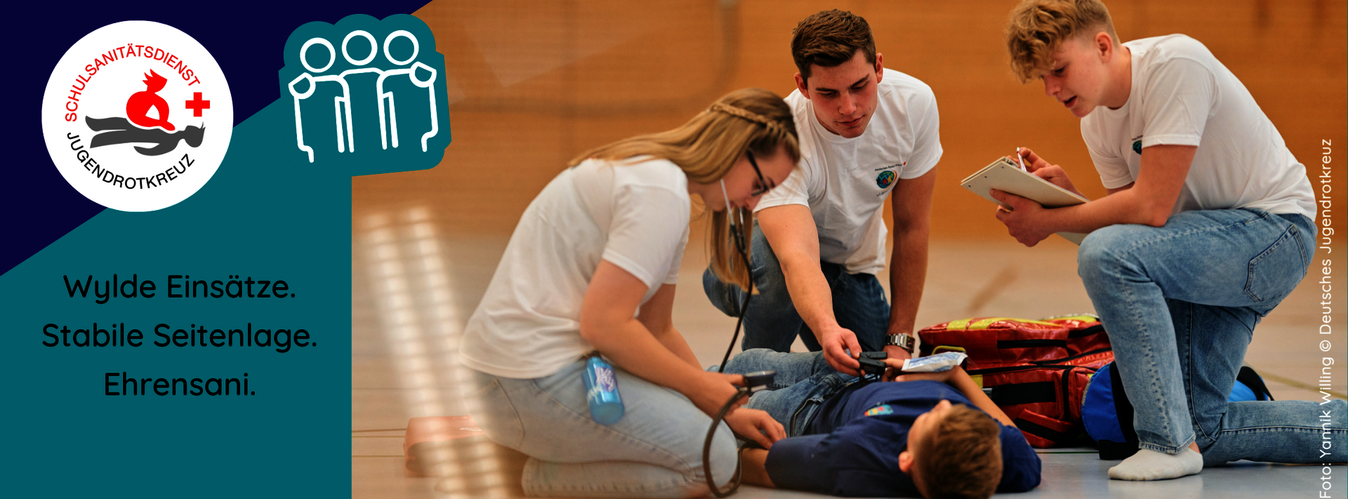 Drei Schulsanitäter*innen knien neben einer Person, die auf dem Boden liegt. Ein Sani misst Blutdruck. Ein anderer notiert etwas. Daneben der Schriftzug"Wylde Einsätze, stabile Seitenlage, Ehrensani."